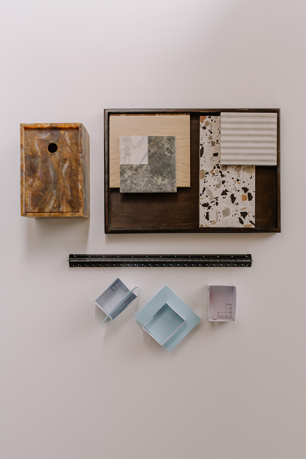 Stone and timber samples on a tray with a scale rule and card room models